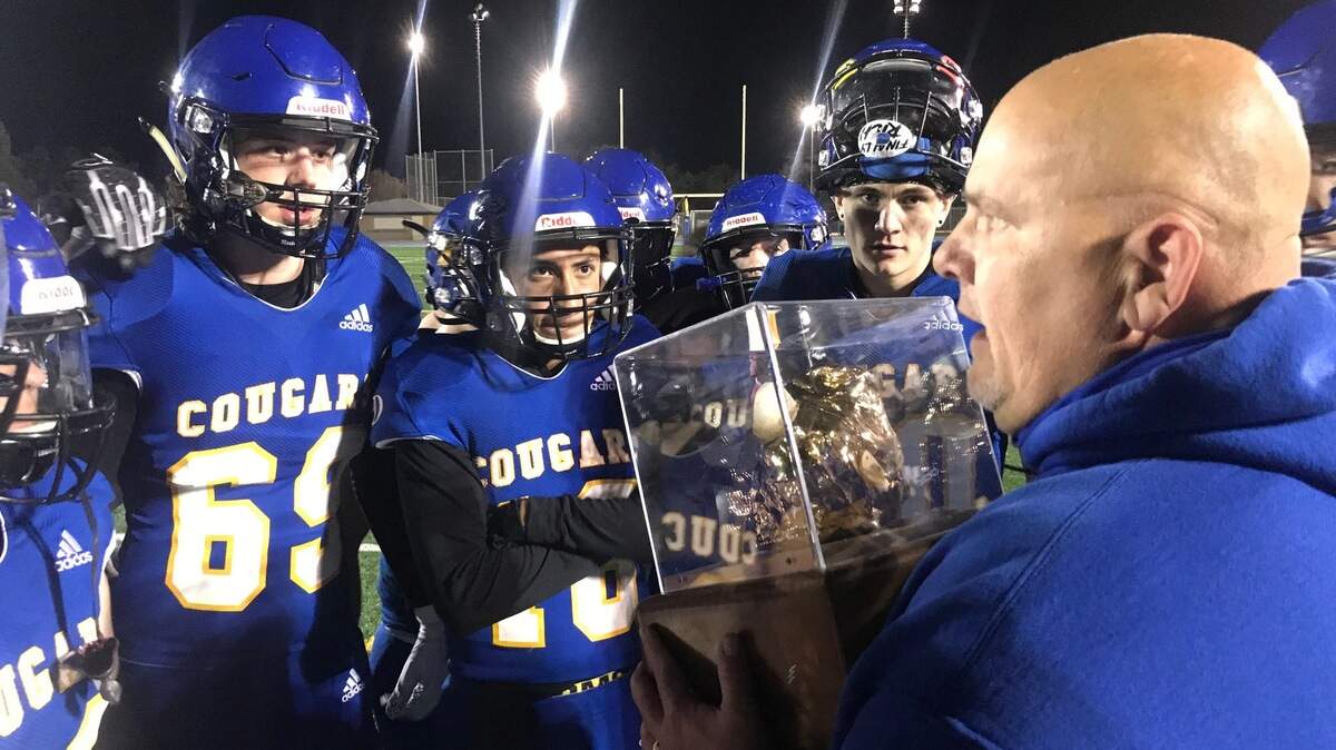 El Dorado coach Christian Mahaffey presents the Gold Nugget trophy to his team after the Cougars beat Union Mine in the annual regional rivalry game.