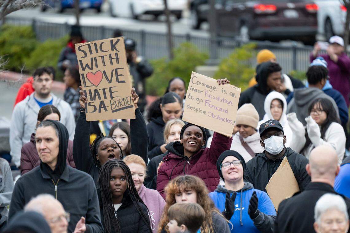 People in the crowd hold up signs before the start of the in MLK365 March for the Dream honoring Martin Luther King Jr. on Monday at Sacramento City College. More than 2,000 people participated in the march.