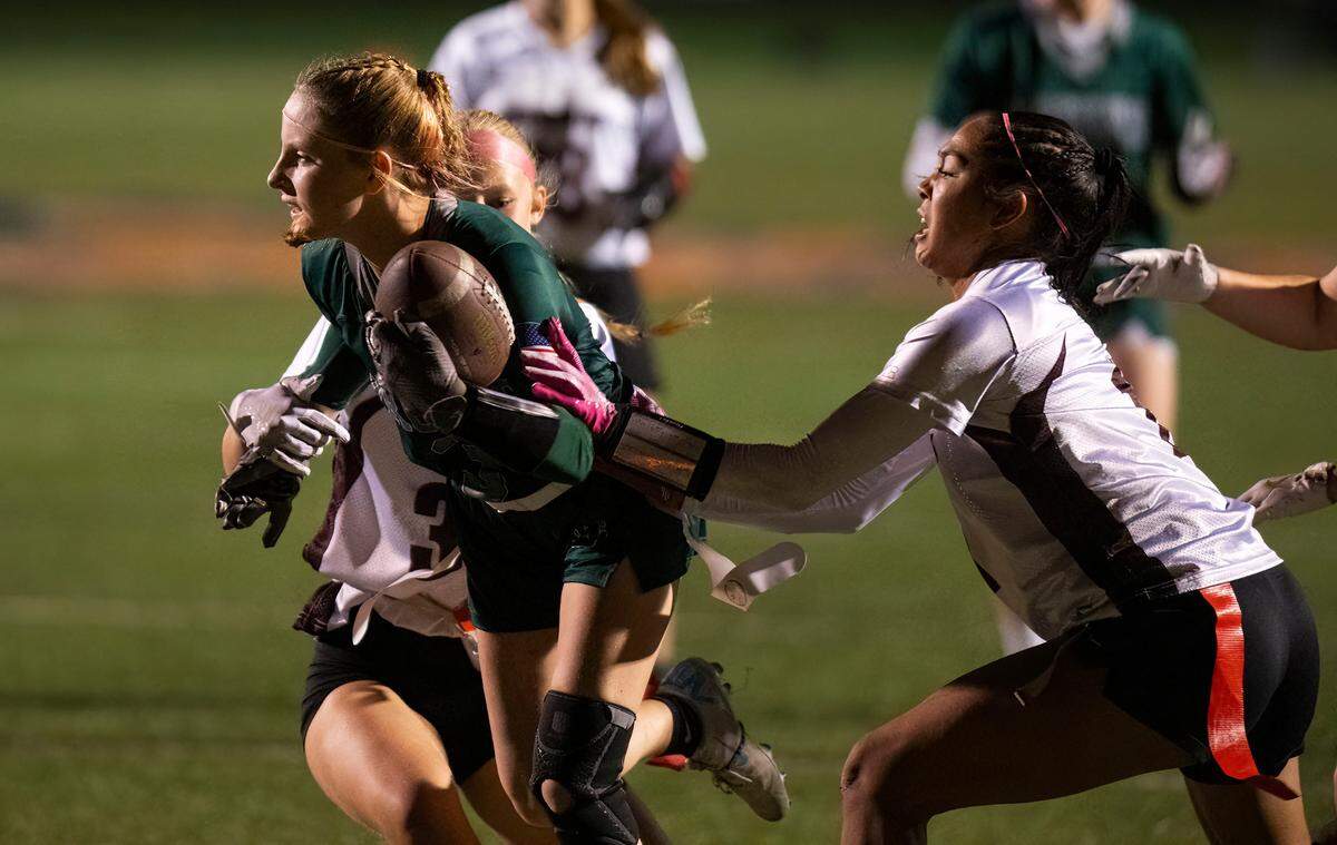 The Ponderosa Bruins’ Molly McFarland (3) scores a touchdown against Woodcreek Timberwolves’ Mckayla Graham (3) and Ryan Nair (1) during the Sac-Joaquin Section Division II championship girls flag football game on Saturday.