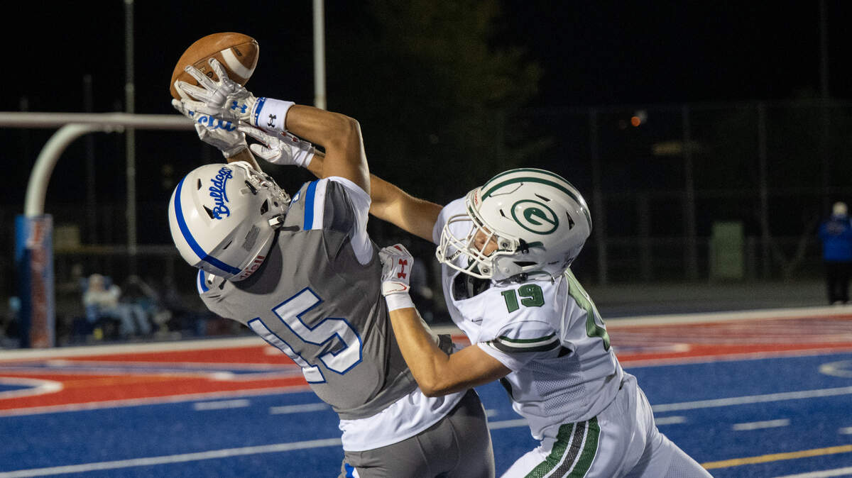 The Folsom Bulldogs’ Arhian Acuna (15) catches a pass as Granite Bay’s James Pease (19) defends in the second half on Friday.