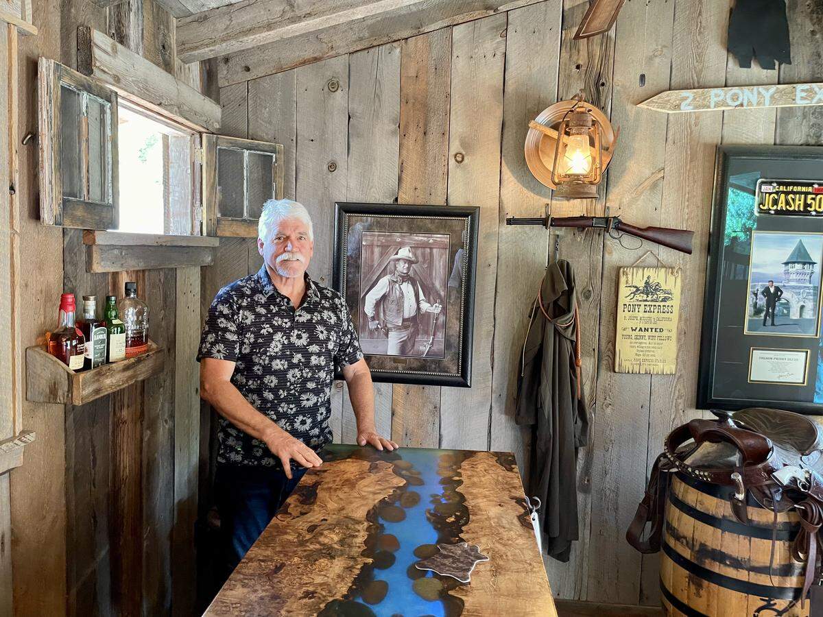 Matthew Garry stands in his backyard saloon with a countertop resembling the flow of the American River from Sutter’s Mill to Folsom.
