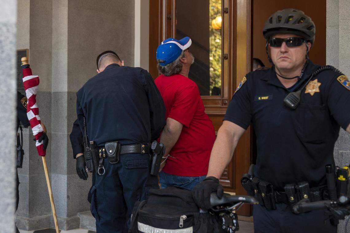 A protester is detained at the Capitol in Sacramento on Friday, May 1, 2020, while demonstrating against Gov. Gavins Newsom stay-at-home order to slow the spread of the coronavirus.