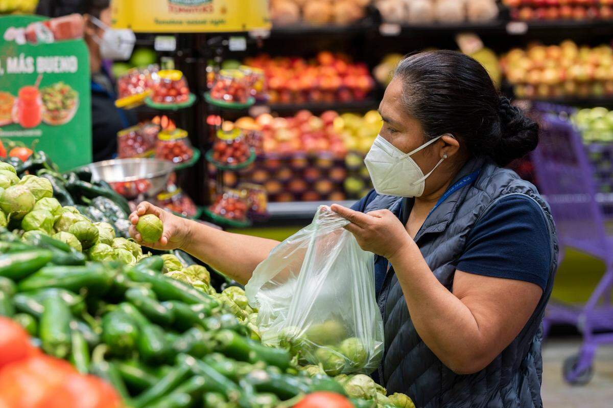 Norma Martinez of Oak Park picks tomatillos during the grand opening of the Rancho San Miguel Market on Wednesday.