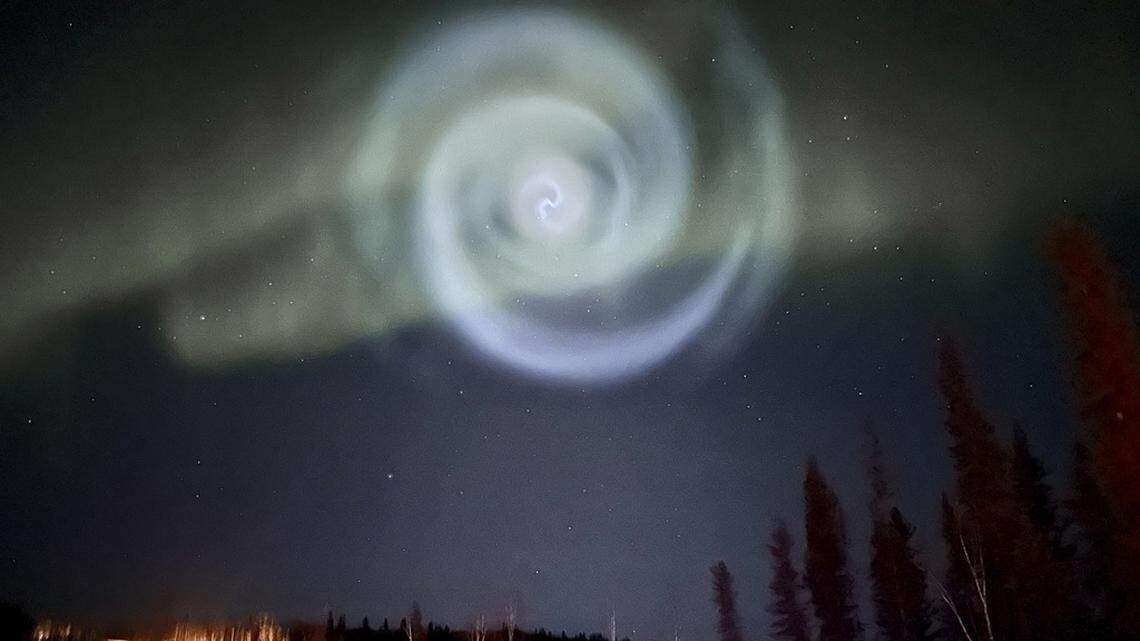 A spiral that formed when excess fuel released from a rocket turned to ice appeared amid the northern lights over Alaska. (Christopher Hayden via AP)
