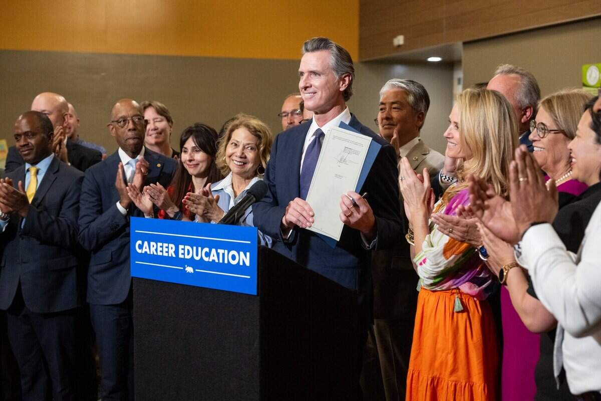 California Gov. Gavin Newsom, joined by First Partner Jennifer Siebel Newsom and public education and workforce leaders, presents the signed executive order on education at River City High School in West Sacramento on Thursday.