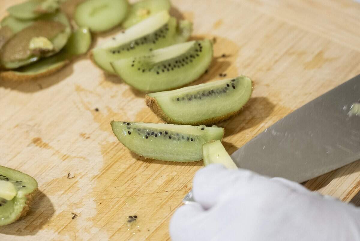 Tina Yang, co-owner of Jumi Shrub, cuts kiwis in her home in Davis on June 22.
