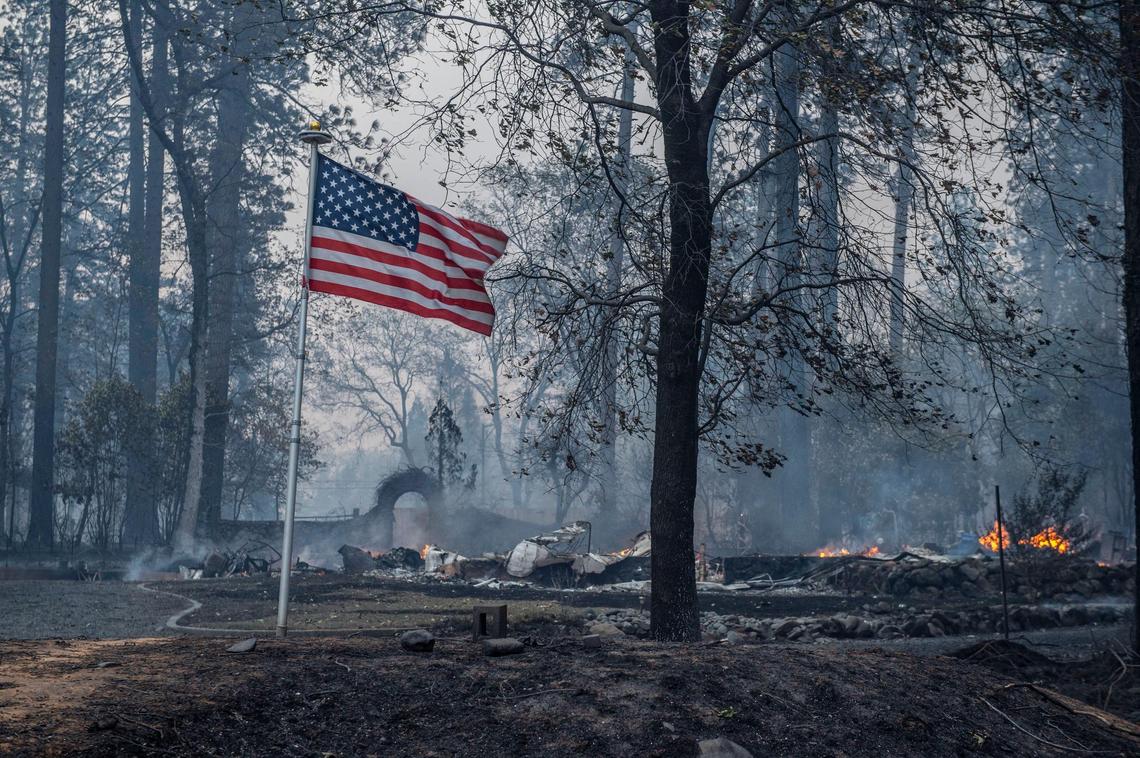An American flag stands unburned at the corner of Pierson and Middle Libby Rd. in Paradise after the Camp Fire destroyed several homes in the area on Thursday, Nov. 8, 2018.