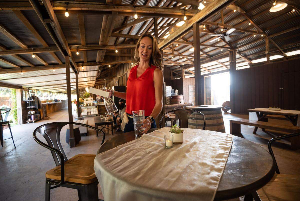 Shannon Ogilvie, hospitality director and tasting room manager, clears a table in the tasting room at Silt Wine Company on Friday, Sept. 3, 2021, in Clarksburg. Her husband, Phil Ogilvie, is one of the owners of at Ogilvie Merwin Vintners, which produces Silt wines from family-owned vineyards.