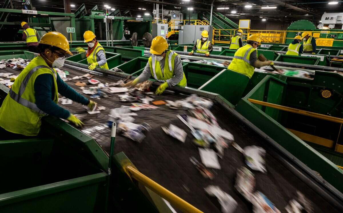 Workers at a conveyer belt of recyclables remove undesirable items at Cal-Waste Recovery Systems in Galt on Tuesday, Dec. 22, 2020. The machine is handles up to 30 tons per hour.