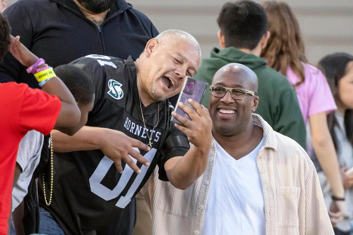 Sacramento Kings coach Mike Brown, right, takes a selfie with a Sacramento State fan in the stands before the NCAA football game between the Hornets and the Northern Arizona Lumberjacks at Hornet Stadium on Saturday.