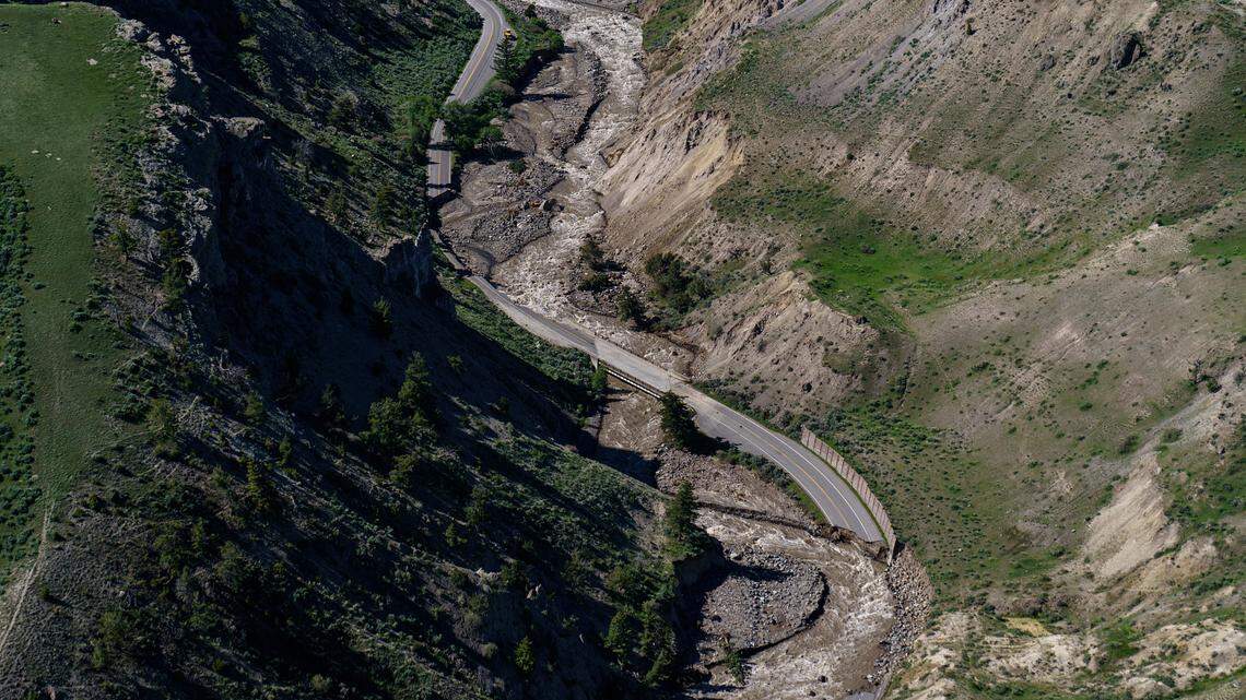 Receding floodwaters flow past sections of North Entrance Road washed away at Yellowstone National Park in Gardiner, Mont., Thursday, June 16, 2022. The number of visitors at Yellowstone National Park is down from previous years months after devastating floods caused the national park’s temporary closure, according to park officials.