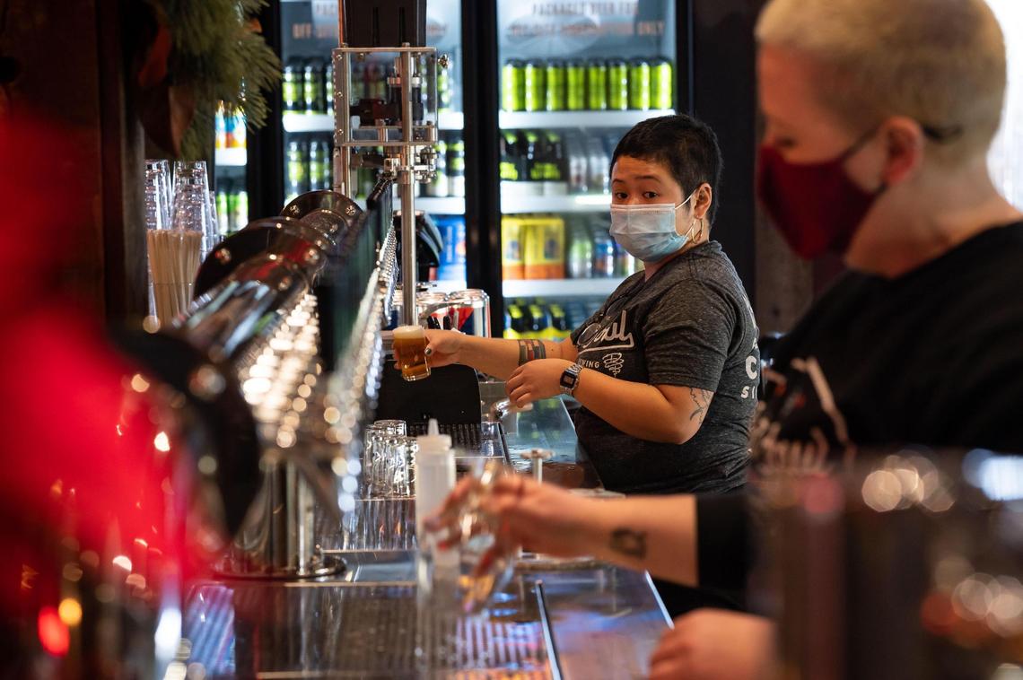 Kristina Baybayan, left, and fellow bartender Miles Feasel keep busy filling glasses during opening day at Dust Bowl Brewing Co.’s Old Town Tap House on Saturday, Dec. 18, 2021, in Elk Grove.