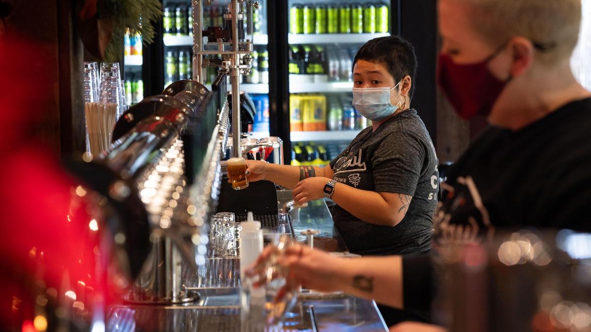 Kristina Baybayan, left, and fellow bartender Miles Feasel keep busing filling glasses during opening day at Dust Bowl Brewing Company’s Old Town Tap House on Saturday, Dec. 18, 2021, in Elk Grove.