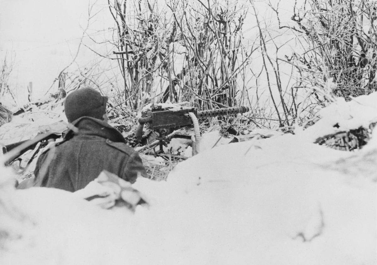 A soldier of the Army’s 101st Airborne Division occupies a snow-covered foxhole position with a machine gun during the Battle of the Bulge in January 1945, near Bastogne, Belgium.