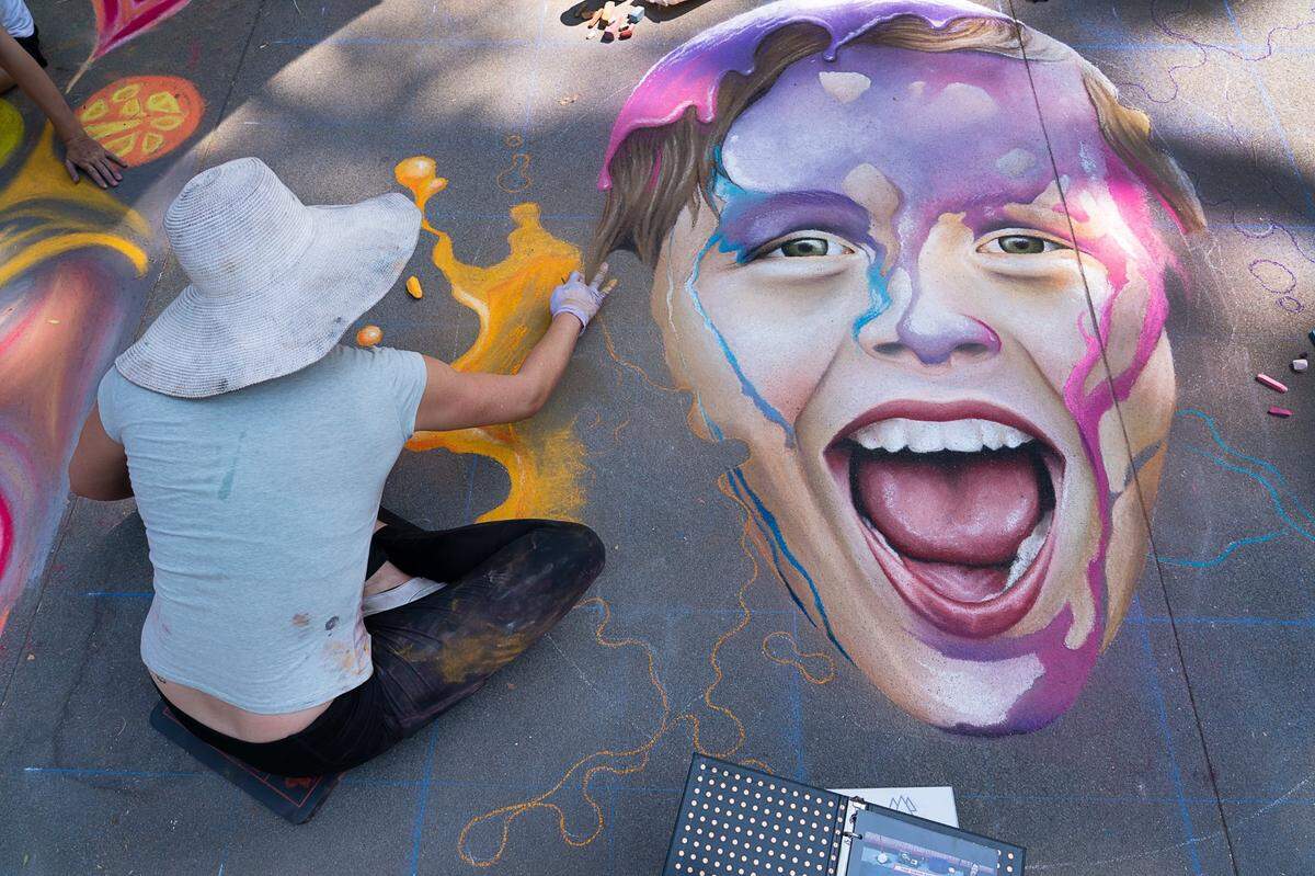 Sacramento artist Jolene Russell creates a chalk painting on the sidewalk at the Chalk it Up festival in Sacramento in 2018.