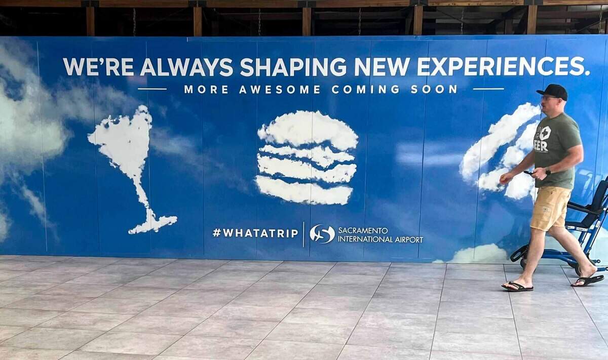 A man walks past a sign alluding to a remake of the airport’s concession program at the Sacramento International Airport. Officials plan farm-to-folk options, Asian eateries and more budget friendly choices.