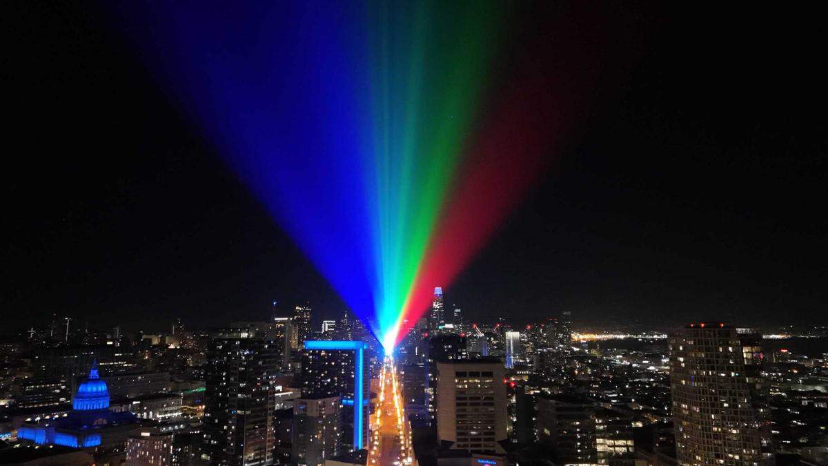 A rainbow of light beams across San Francisco from above Market Street on Wednesday, Nov. 15, 2023. Nu-Salt Laser Light Shows International of Folsom partnered with Illuminate SF to create a weeklong light show for the APEC summit.