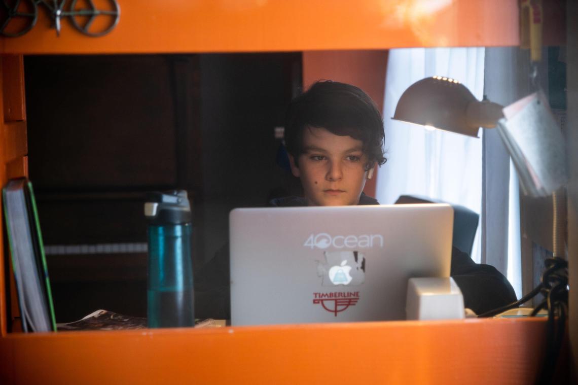 Diego Martinez-Vaughan, 12, does school-related work in a shared space at home Tuesday, May 12, 2020, in Sacramento.