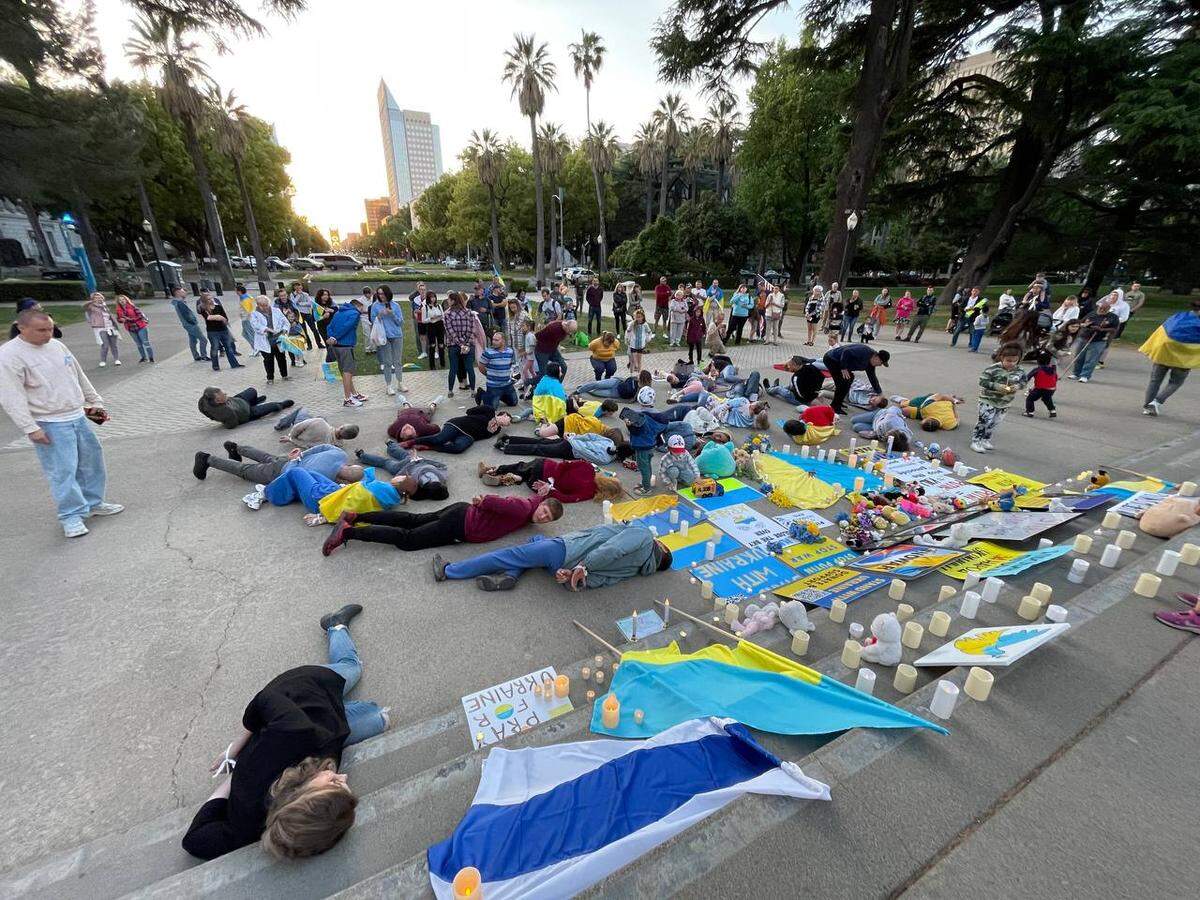 Activists from the Sunflower Society, an organization that holds monthly protests at the state capital to protest Russia’s ongoing invasion of Ukraine, stage a die in April, 10, 2022 to protest the massacre of civilians in Bucha, Ukraine.