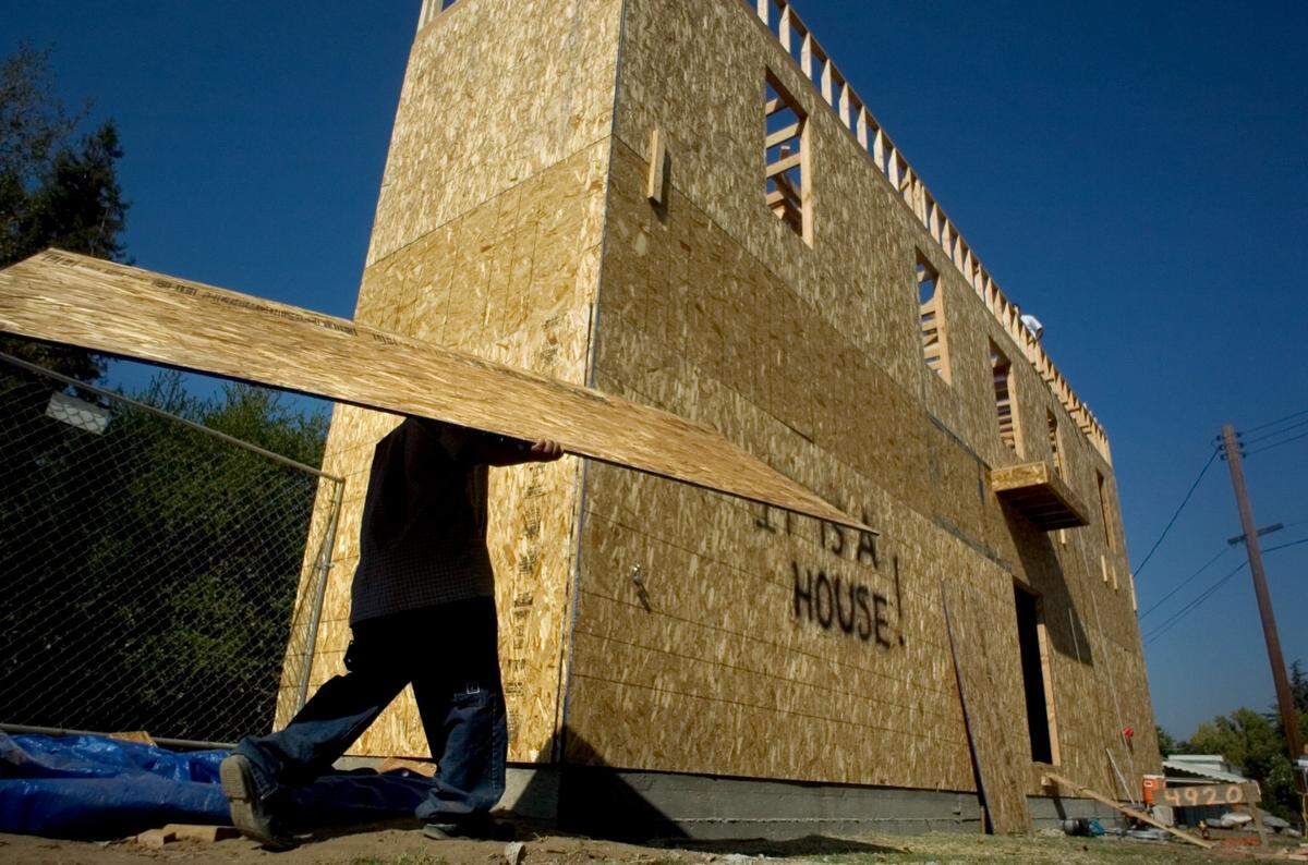 Alberto Gabriel carries a wood panel as he helps build an unusually skinny house in South Land Park in 2005. Owner John Johnston spray painted “It is a House!” on the side of the 1,100 square-foot structure to satisfy the curiosity of the passersby.
