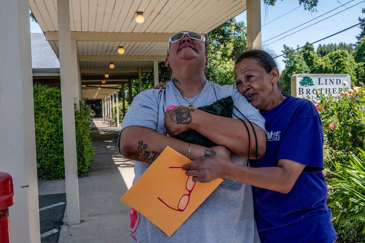 Felicia Clark, left, throws her head back in despair while clenching her daughter Felicia Brent-Valasquez’s ashes as her mother Arteenis Velasquez holds her death certificate while comforting her outside the Lind Brother’s Funeral Home on July 20.