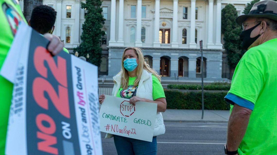 Erica Mighetto, an Uber and Lyft driver, organizes a gig workers rally against Proposition 22 outside the state Capitol on Thursday, Oct. 15, 2020.