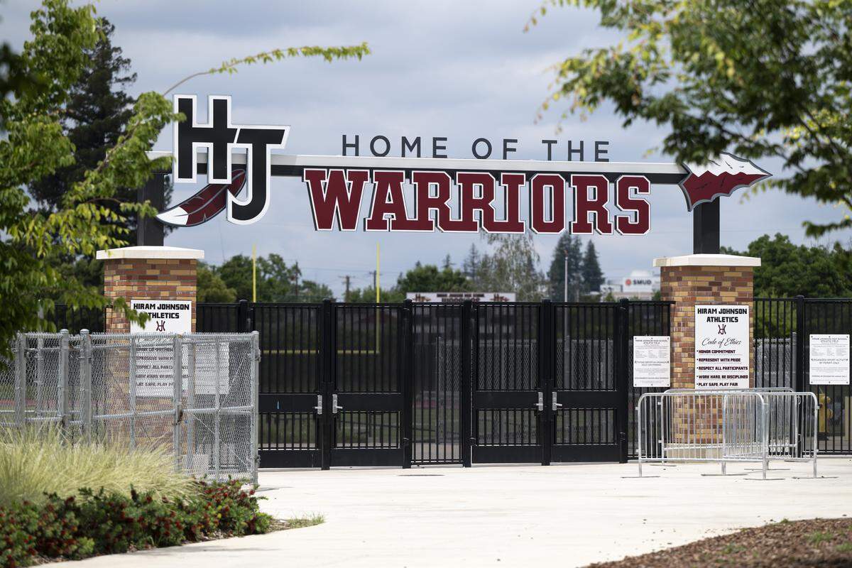 A sign featuring an arrow and a feather decorates the entrance to the football field at Hiram Johnson High School in Sacramento on Tuesday. The school’s principal, Garrett Kirkland, says that if they’re forced to change their nickname from the Warriors, the cost of redoing the sporting facilities which bear the name — including the new football stadium which was completed a few years ago — could add up.