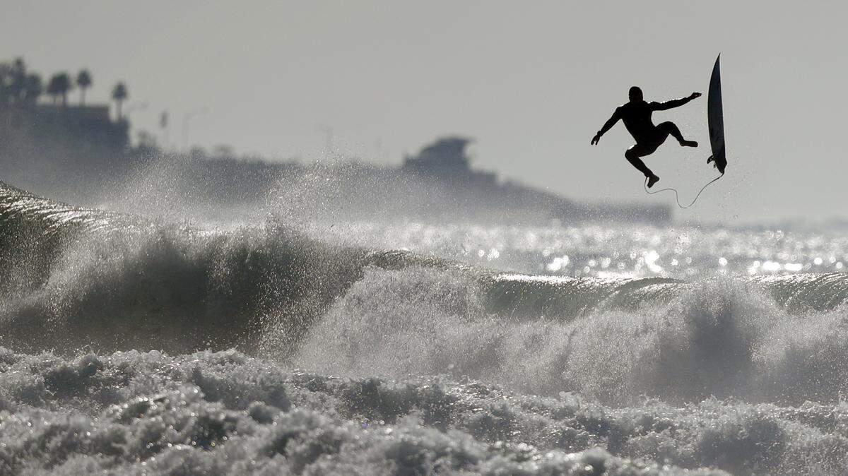 A surfer exits a wave while surfing at Black’s Beach Tuesday, Dec. 18, 2018, in San Diego. Large surf continued to pound the California coast Tuesday, as officials warned of dangerous currents along the beaches and hazardous conditions at sea. (AP Photo/Gregory Bull)