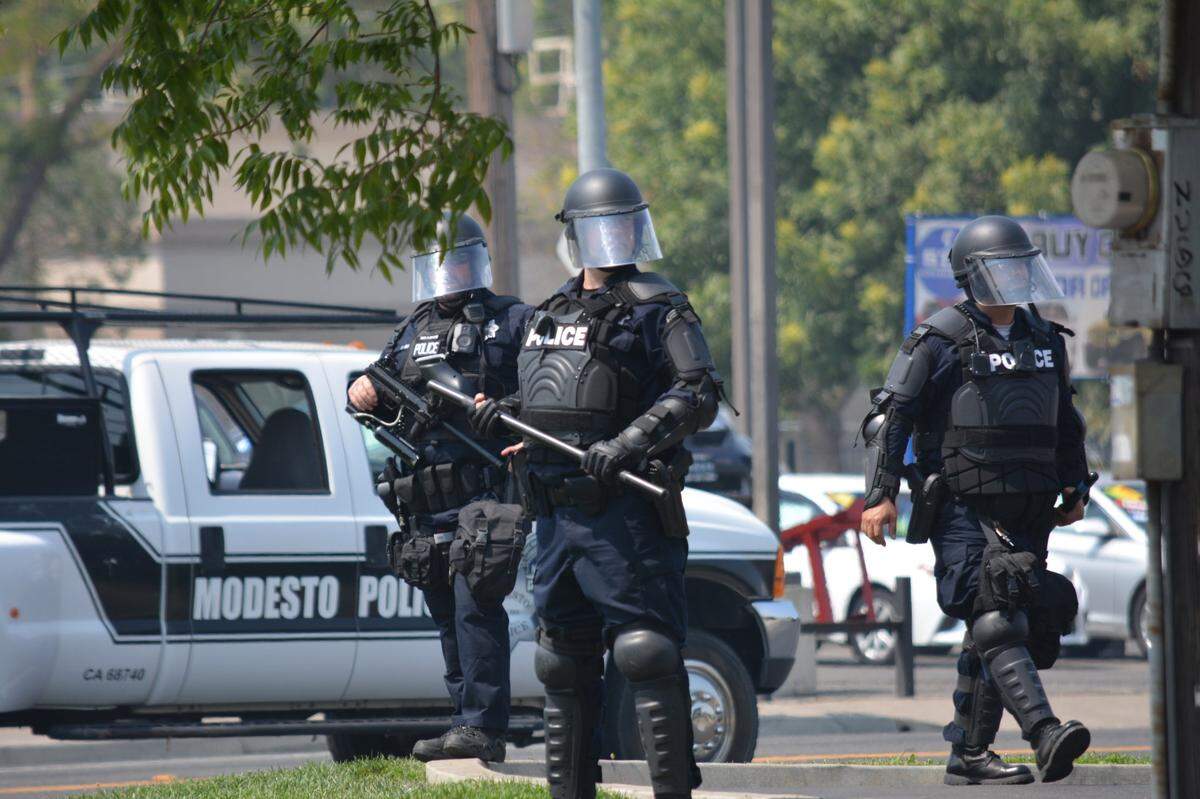 Modesto police stand in tactical gear stand in August after dispursing crowds from a “straight pride” rally that was declared unlawful unlawful after a fight broke out. The city has more than 1,000 employees in the CalPERS system.