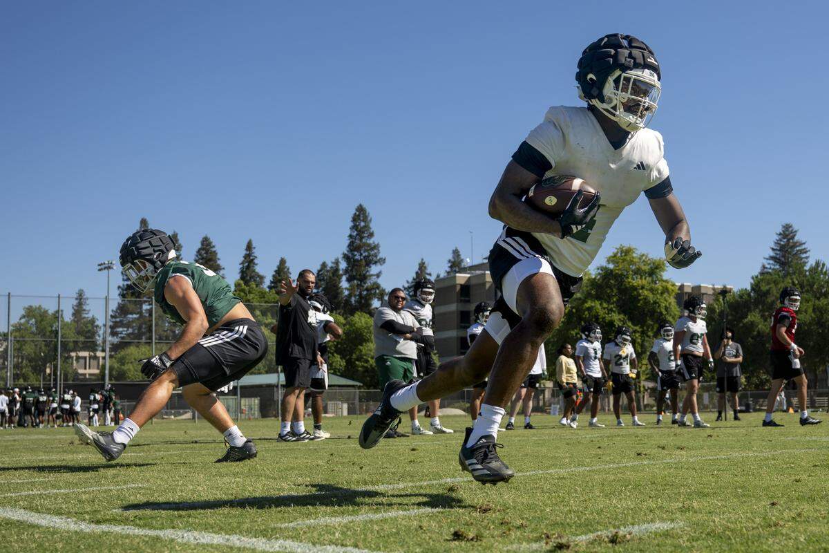 Running back Damian Henderson II rushes through inside linebacker Alex Rocha during the first practice of the 2025 season in Sacramento on Friday, August 1, 2025.