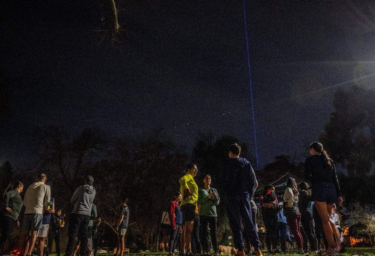 The Sacramento Kings beam lights the sky as participants of the running and walking group Corremos Sacramento gather in January after a stroll around McKinley Park in East Sacramento.