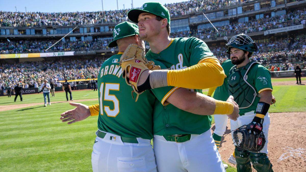 Oakland A’s pitcher Mason Miller congratulates first baseman Seth Brown after the team defeated the Texas Rangers in its final game at Oakland-Alameda County Coliseum on Sept. 26.