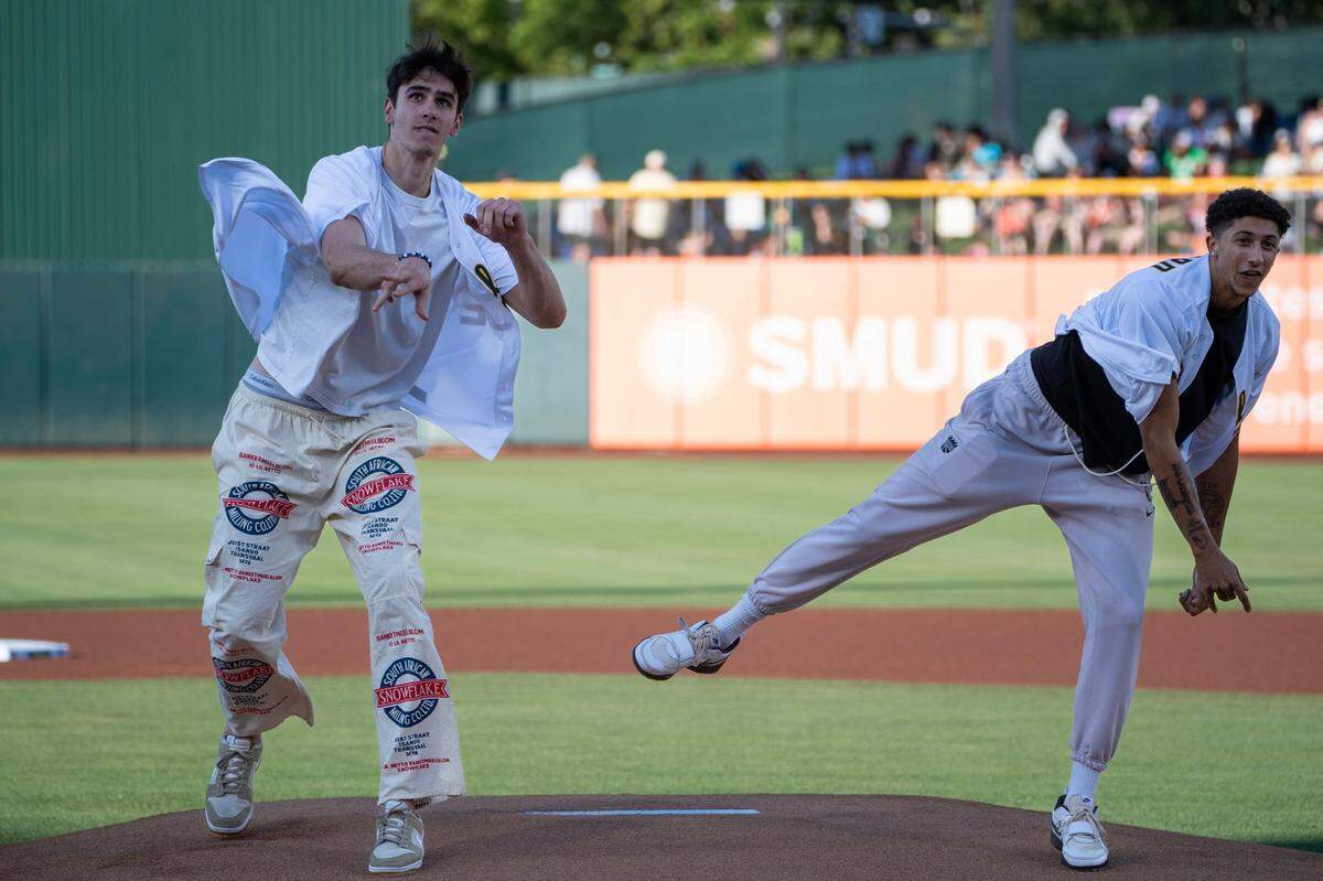 Sacramento Kings draft picks Maxime Raynaud, left, and Nique Clifford throw out the ceremonial first pitch before the Athletics faced the San Francisco Giants on Saturday at Sutter Health Park in West Sacramento. The Kings selected Clifford and Raynaud in the draft in late June.