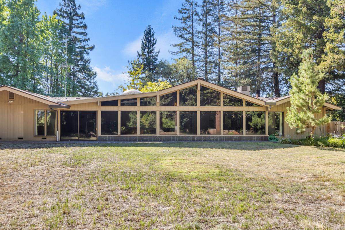 Mature redwood trees frame the 1.3-acre Orangevale property, creating a private woodland setting for this architectural gem.