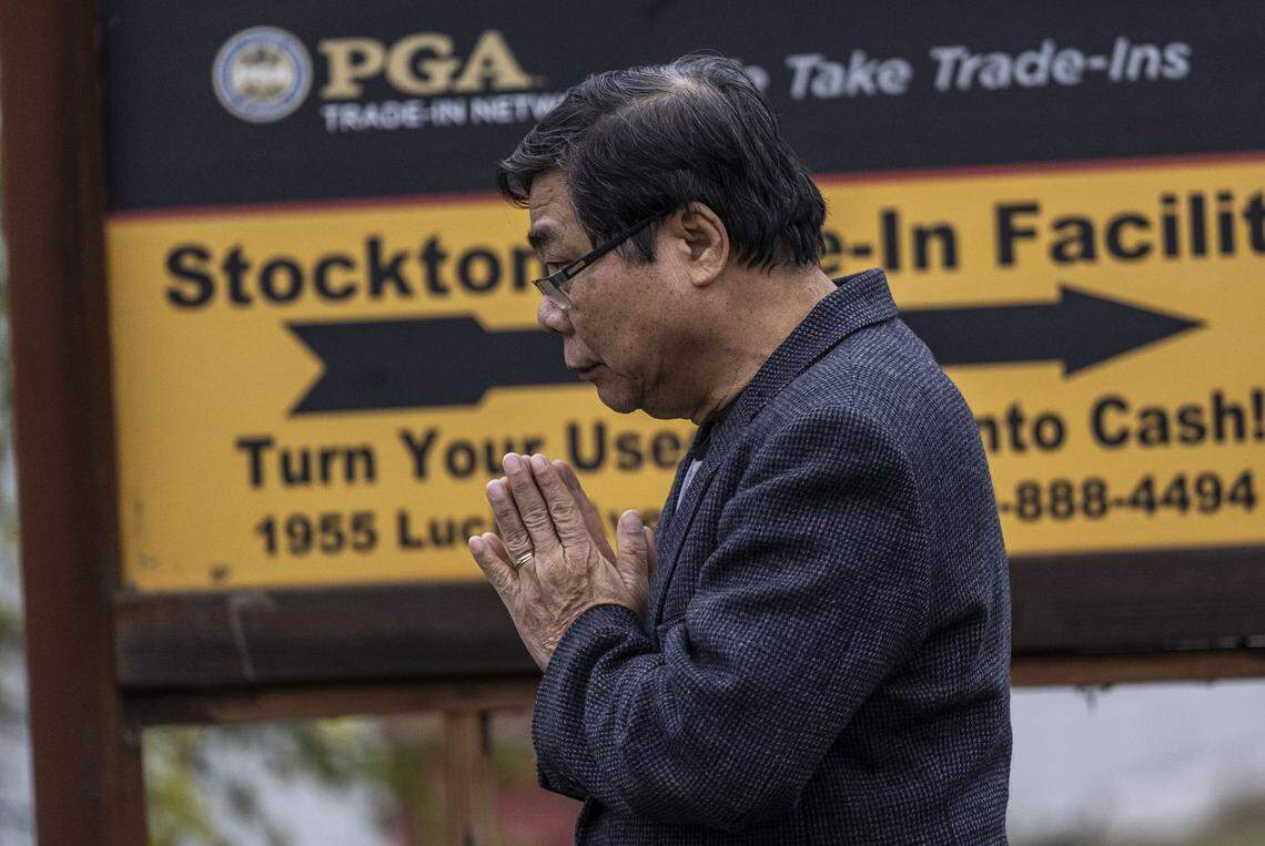 Stockton resident Truong Nguyentan prays Monday in front of the Lucile Avenue building near Stockton where a mass shooting happened over the weekend. Nguyentan runs a tax services business nearby.
