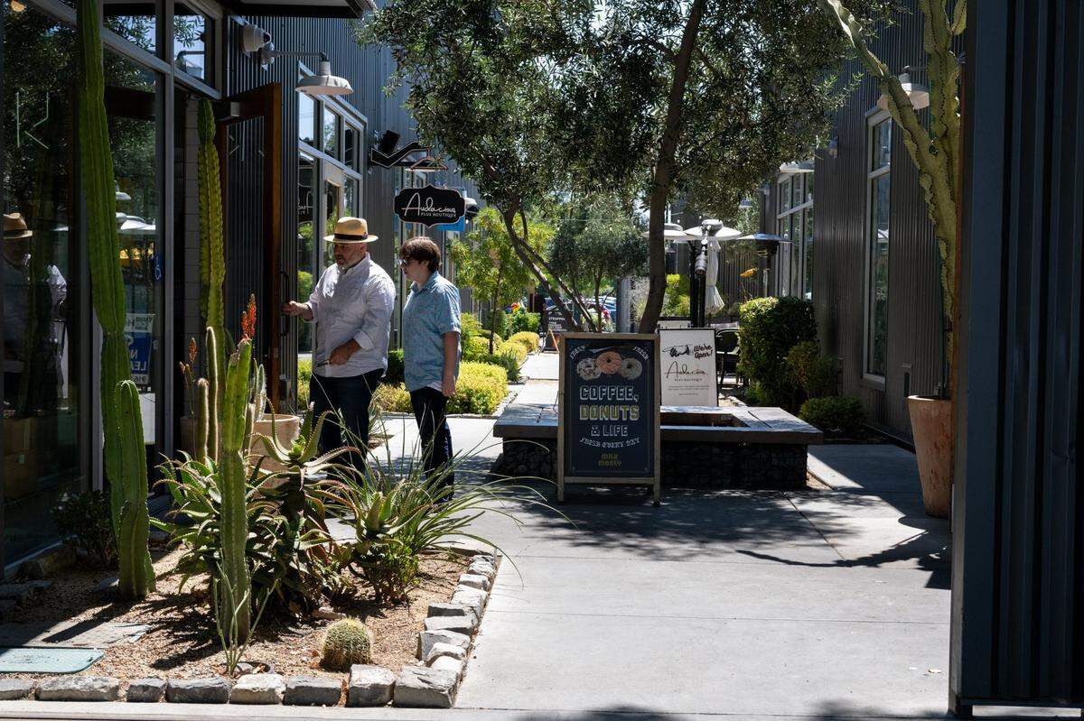 People enter a shop on the R Street corridor, a two-block retail, office and residential development in midtown Sacramento.
