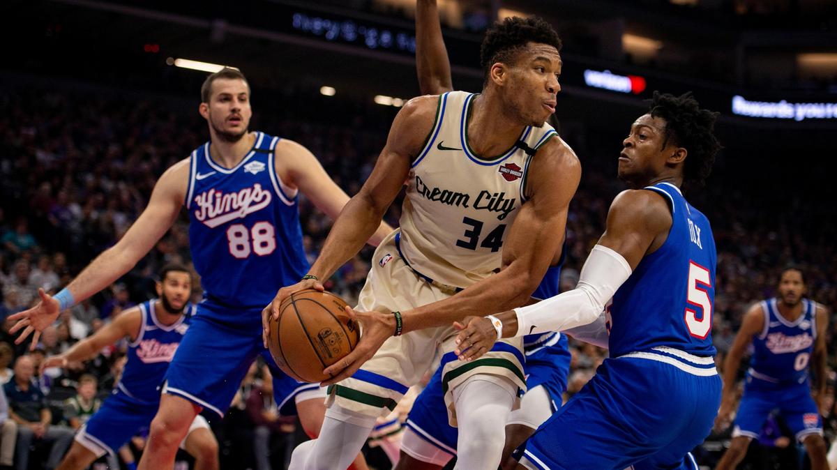 Milwaukee Bucks forward Giannis Antetokounmpo (34) looks for a way around Sacramento Kings guard De’Aaron Fox (5) and Sacramento Kings forward Nemanja Bjelica (88), Friday, Jan. 10, 2020, during the first half of the game at the Golden 1 Center