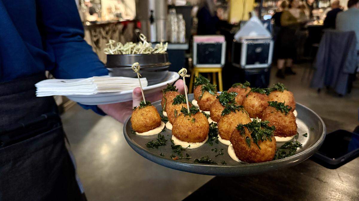 A server passes saffron risotto aranchini as a bite at Magpie Cafe’s in Sacramento, CA on Wed., April 1. The farm-to-fork restaurant celebrated its 21st anniversary, on April 1, 2026, with an event serving free food to locals and industry folk.