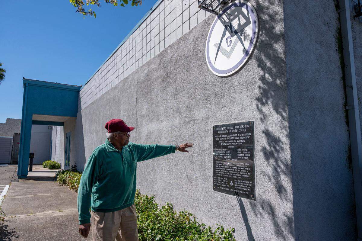 George Blue shows a building placard outside the Sacramento Prince Hall Masonic Community Activity Center on Saturday, April 1, 2023. The 86-year-old leader of the Sacramento chapter of the Prince Hall Freemasons, a Black branch of the fraternal organization, has found himself in the position of trying to retain his hall’s charitable-purpose tax exemption