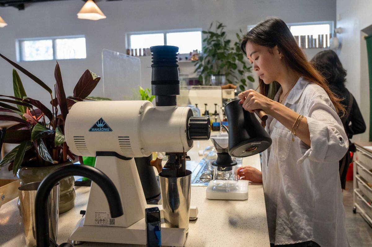 General manager Jenny Nguyen pours hot water from kettle at Chloe Ca Phe in midtown on July 8, 2025.