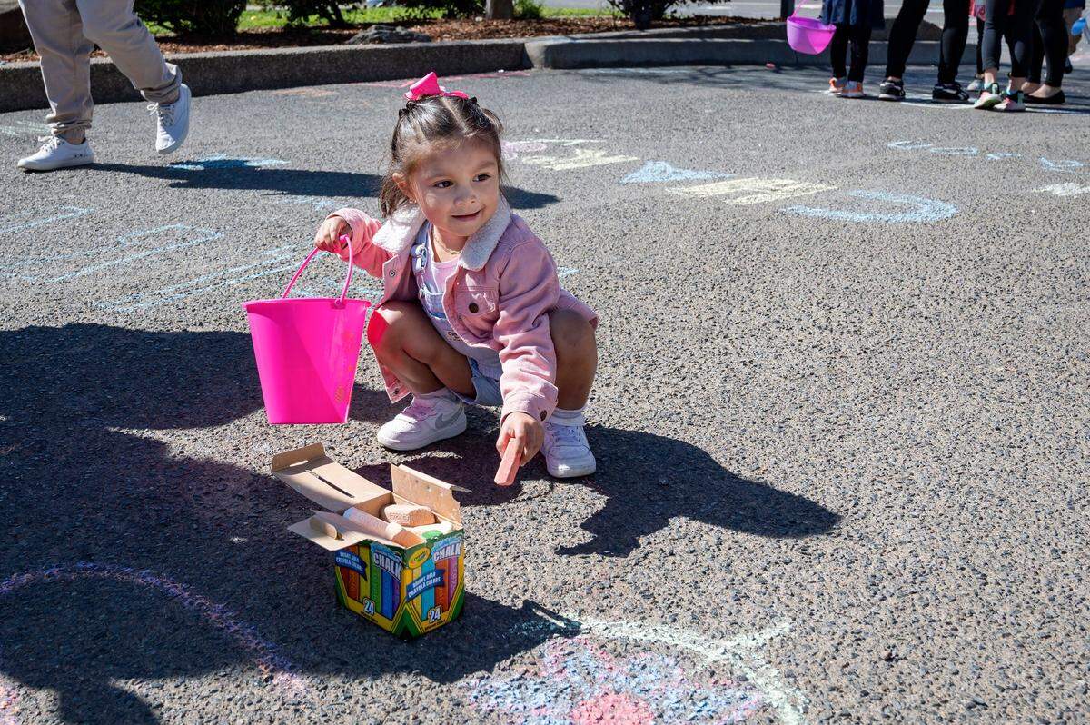 Sofia Meja, 3, draws with chalk during the Haggin Oaks Easter Egg Hunt on Sunday, April 9, 2023, in Sacramento.
