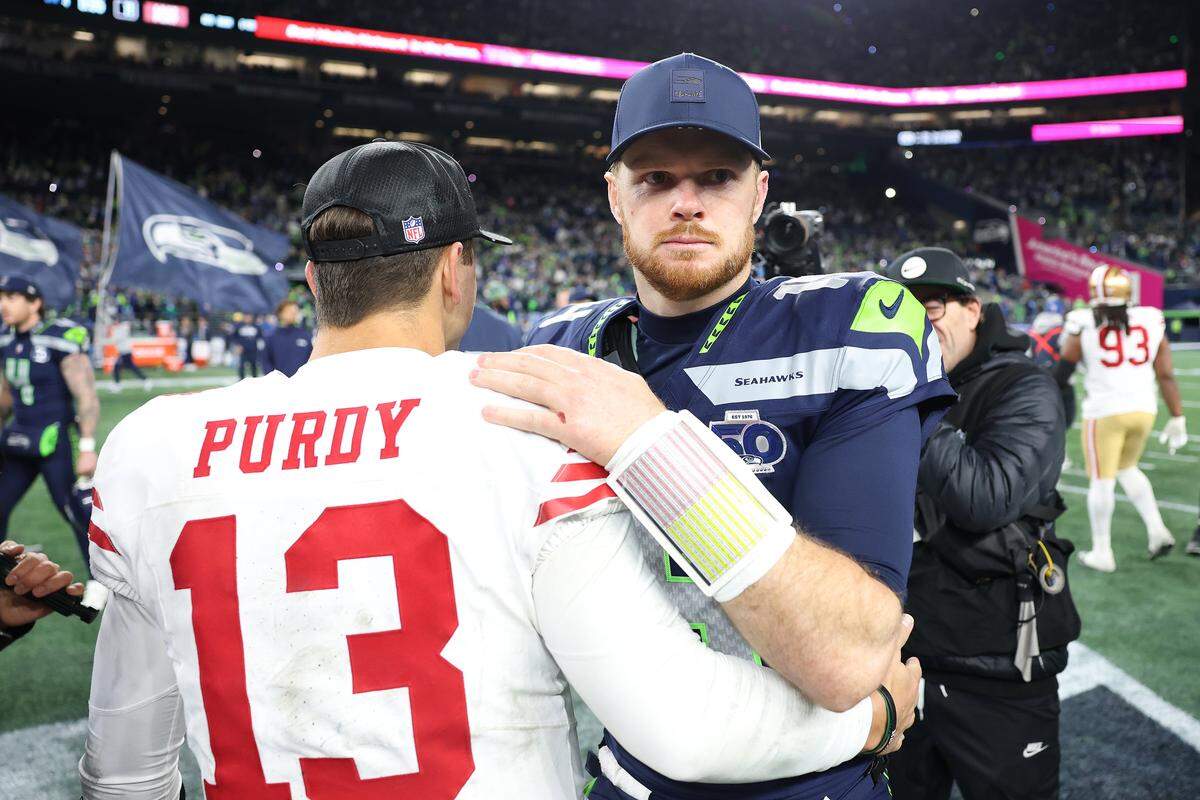 SEATTLE, WASHINGTON - JANUARY 17: Brock Purdy #13 of the San Francisco 49ers and Sam Darnold #14 of the Seattle Seahawks embrace after the game in the NFC Divisional Playoff game at Lumen Field on January 17, 2026 in Seattle, Washington.  (Photo by Sean M. Haffey/Getty Images)
