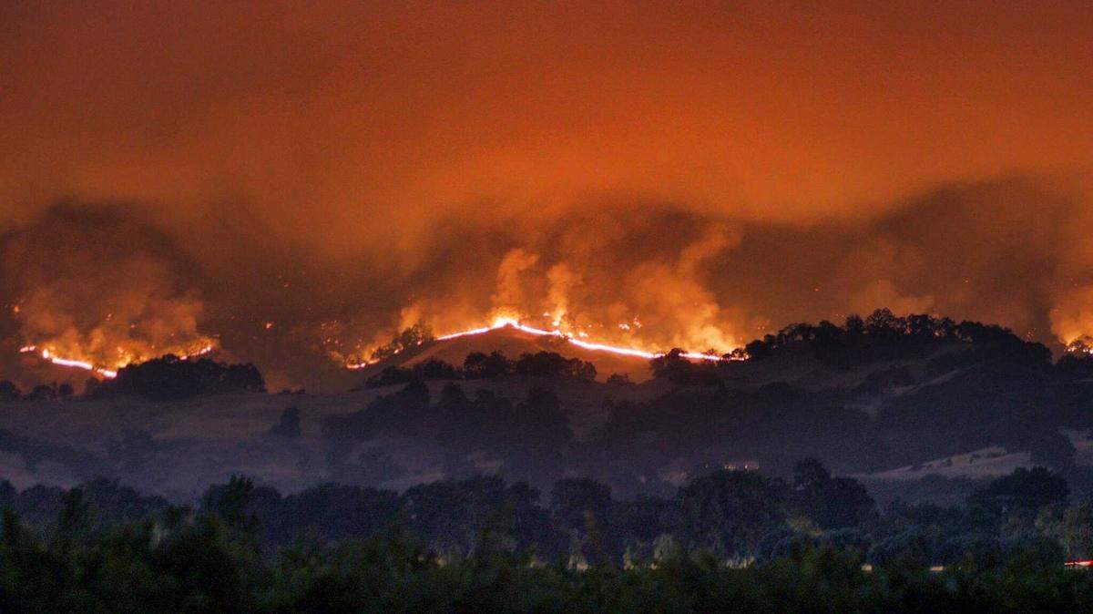 The River Fire, part of the Mendocino Complex Fire, rages down a hillside toward U.S. Highway 101 on Friday night just north of Hopland.  The fire burned 24,000 acres by Sunday.