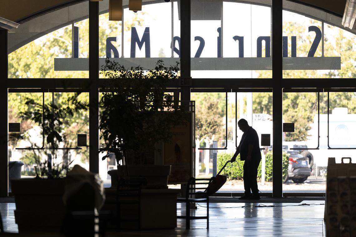 A worker vacuums as Sunrise Mall prepares to open for the day in Citrus Heights earlier this month. 