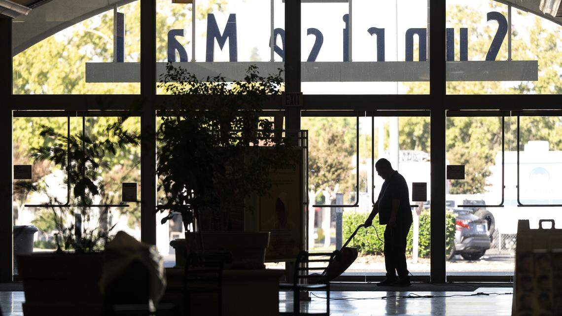 A worker vacuums as Sunrise Mall prepares to open for the day in Citrus Heights on Tuesday, Sept. 16.