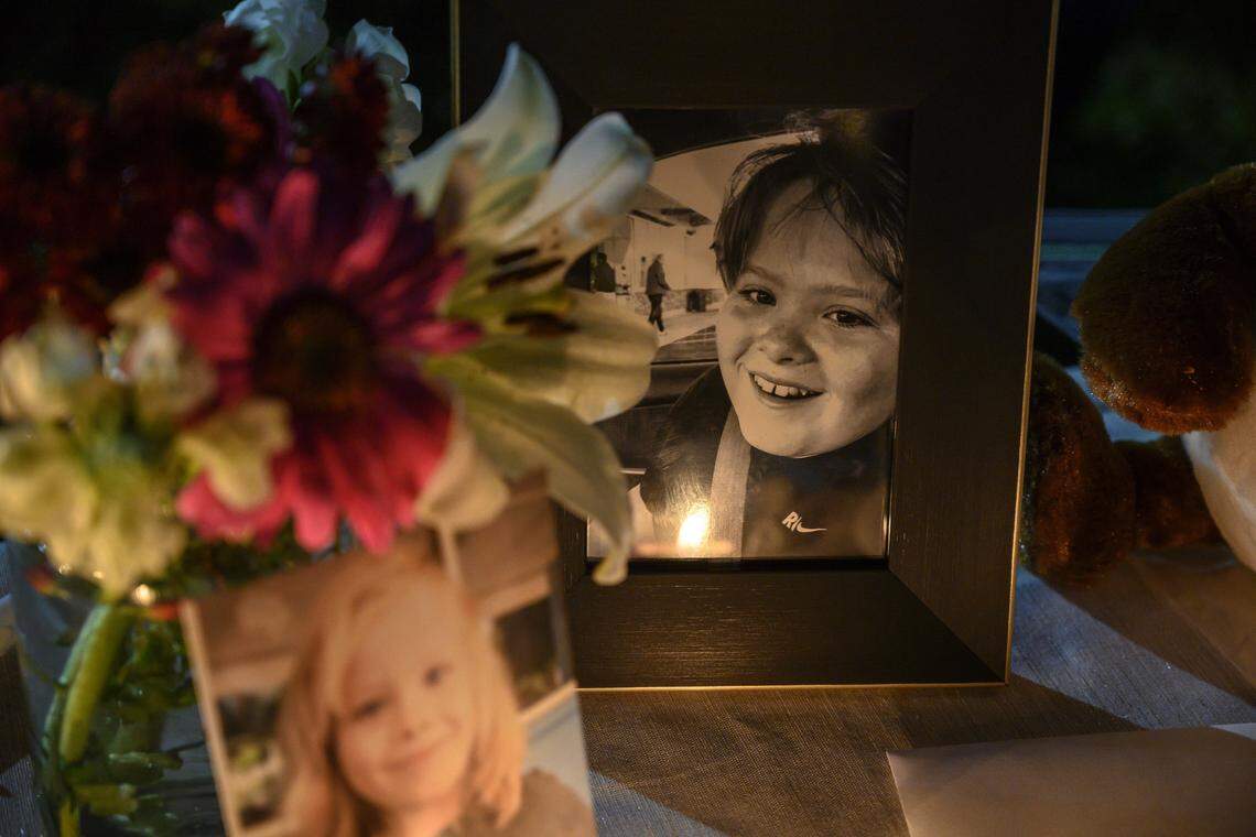A candle is reflected in one of two photographs of Max Benson, 13, at his vigil at Guiding Hands School on Saturday, Dec. 15, 2018, in El Dorado Hills, Calif. Benson, who had autism, became unresponsive while in a restraint hold at the school and died a day later at UC Davis Medical Center.