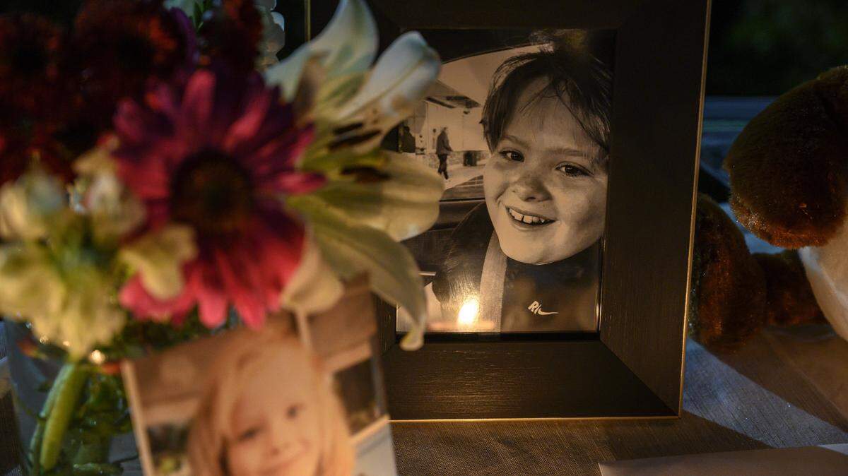 A candle is reflected in one of two photographs of Max Benson, 13, at his vigil at Guiding Hands School on Saturday, Dec. 15, 2018, in El Dorado Hills, Calif. Benson, who had autism, became unresponsive while in a restraint hold at the school and died a day later at UC Davis Medical Center.