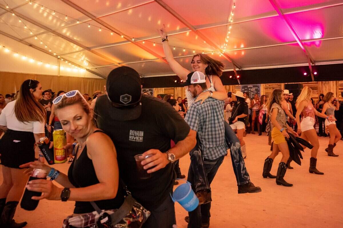 Country-music fans line dance in the River City Saloon Dance Hall at Sacramento’s first-ever GoldenSky country music festival Saturday, Oct. 15, 2022, at Discovery Park. The two-day event featured headliners Tim McGraw and Sam Hunt, as well as Brothers Osborne, Midland, Carly Pearce and more.