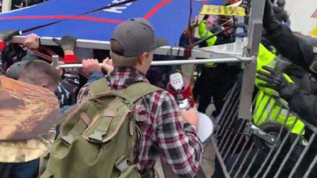 A federal response in opposition to a motion to dismiss charges against Sean Michael McHugh, 34, of Auburn â seen holding a megaphone in this video image provided by prosecutors â alleges that McHugh sprayed U.S. Capitol Police officers with a chemical substance and assaulted them with a metal sign during the Jan. 6, 2021, insurrection at the U.S. Capitol.
