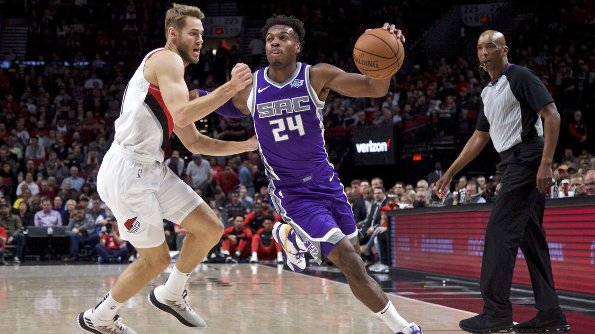 Kings guard Buddy Hield, right, drives past Portland Trail Blazers forward Jake Layman during the first half of an NBA preseason basketball game in Portland, Ore., Friday, Oct. 12, 2018.